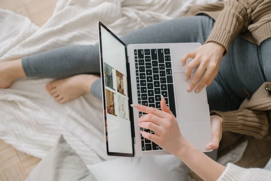 A modern workspace showing hands analyzing marketing data on a laptop and paper documents.